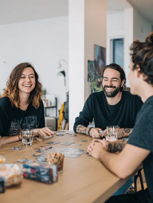 Groupe d’amis jouant aux cartes pendant que Major'Dom 67 s’occupe du ménage
